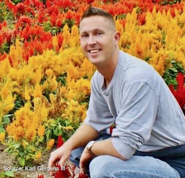 Image of a man kneeling in front of a flowering garden